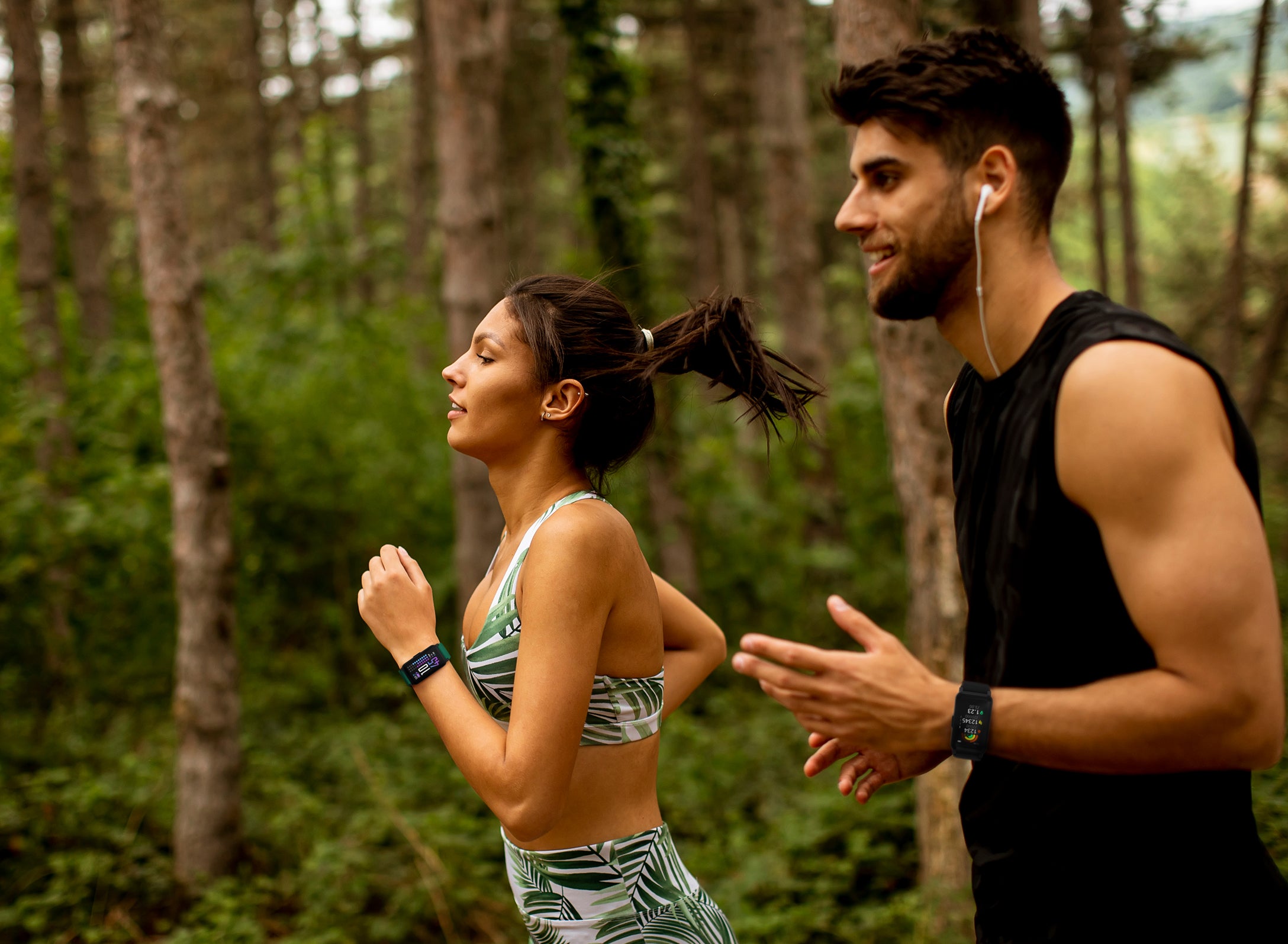 Two people running in a forested area