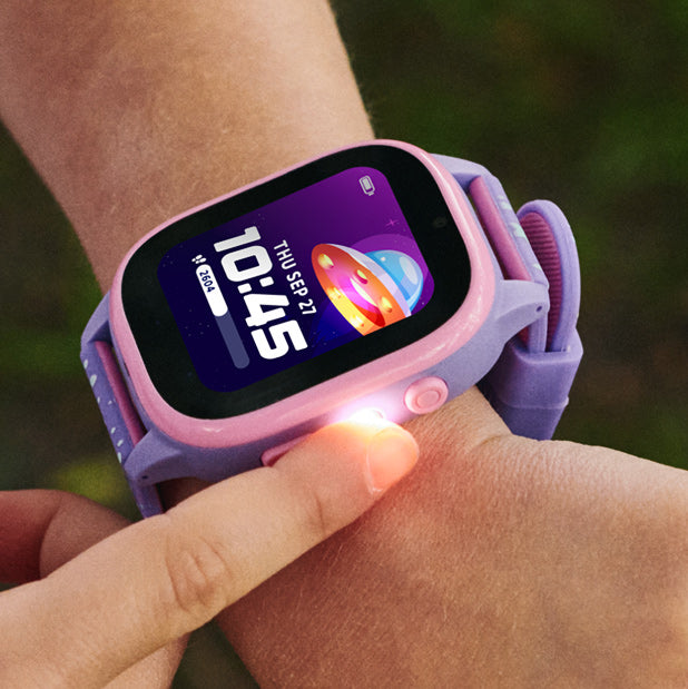 Smartwatch with a purple band on a wrist against a blurred green background